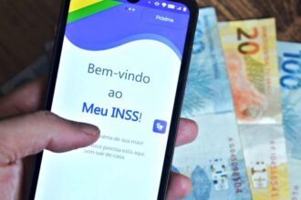 Meu INSS aplicativo e dinheiro ao fundo - Créditos: depositphotos.com / thenews2.com